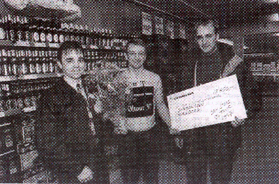 Souchef i Super Brugsen i Glsborg, Carsten Pedersen, fr her overrakt blomster af Flemming Tolstrup fra Tuborg Depot og check af Claus Larsen fra Carlsberg Depot, som det synlige bevis p, at man er vinder af "Den Store ltour 1997".